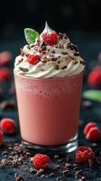 Delicious raspberry cream drink adorned with mint leaves and chocolate shavings served in a clear glass photo
