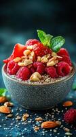 Colorful bowl of fresh raspberries and strawberries topped with nuts and mint on a dark background photo