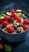 Colorful berry bowl topped with nuts and seeds served in a textured blue bowl for a healthy breakfast option photo