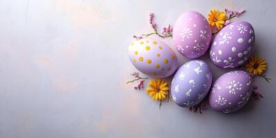 Brightly decorated Easter eggs surrounded by fresh flowers on a textured pastel background photo