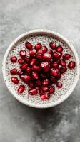 Chia pudding topped with vibrant pomegranate seeds on a textured background photo