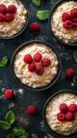 Creamy rice pudding topped with fresh raspberries served in elegant bowls on a dark surface photo