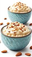 Delicious almond rice pudding served in blue bowls with sliced almonds on top and scattered around the bowls photo