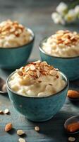 Delicious rice pudding topped with toasted almonds served in vibrant blue bowls photo