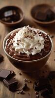Rich chocolate mousse with whipped cream and chocolate shavings presented in an elegant bowl on a wooden table photo
