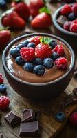 Delicious chocolate mousse topped with fresh berries and chocolate pieces served in a rustic setting photo