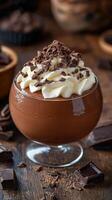 Rich chocolate mousse topped with whipped cream and chocolate shavings in a cozy dessert setting photo