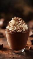 Indulgent chocolate dessert topped with whipped cream and cocoa powder served in a glass photo