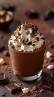 Delicious chocolate dessert topped with whipped cream and chocolate shavings served in a glass on a rustic wooden surface photo