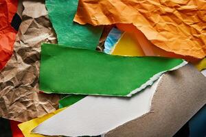 Torn and crumpled color papers surface with place for terxt photo