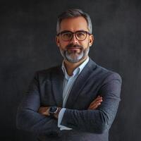 Portrait of a successful businessman with beard and glasses standing in front of black background photo