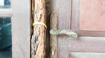 An old doorknob with a weathered door frame. photo