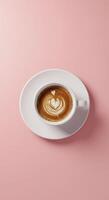 A cup of coffee with a heart in the middle on a pink background photo