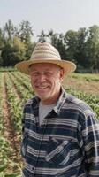 A smiling man in a straw hat standing in a field photo