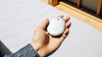 A hand holding a small discshaped implant device showcasing its ergonomic design and integrated wireless connectivity features with a soft glow suggesting it is active.. photo