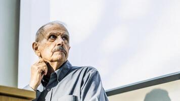 A closeup of an elderly mans furrowed brow reflecting deep thought while he contemplates the ethical aspects of gene editing technologies presented during the consultation.. photo