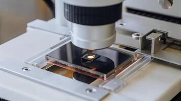 A closeup of a highresolution camera setup for livecell imaging showcasing the luminous glow of fluorescenttagged cells interacting under a clear microscope stage.. photo