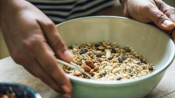 A focus on a participants hands mixing a homemade energy bar mixture with oats nuts and dried fruits exemplifying handson learning and experimentation in nutritional biohacking.. photo