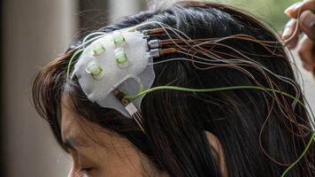 A detailed view of the EEG sensors electrodes secured with conductive gel on a users scalp emphasizing the connection between the technology and the human brain as research data is. photo