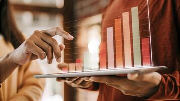 A focused shot of a holographic bar chart floating in the air with a user pointing at specific data points to analyze business performance in realtime.. photo