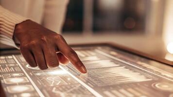 A closeup of a users hand interacting with a holographic display rotating futuristic icons and clicking on various optimization tools in a welllit workspace.. photo