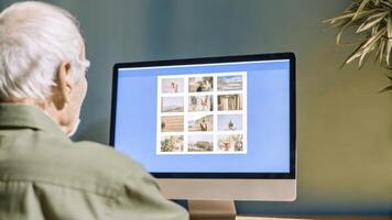 Senior man browsing online photo album on computer