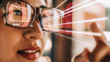 A closeup showing a user with augmented reality glasses interacting with a holographic data integration system with data visuals reflecting in their lenses.. photo