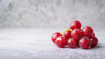 A cluster of fresh red currants with water droplets on a textured surface. photo