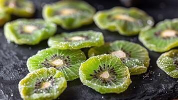 Dried kiwi slices arranged on a dark surface, showcasing their vibrant color and texture. photo