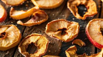 Dried apple slices arranged on a rustic wooden surface, sprinkled with salt. photo