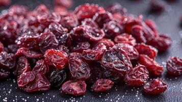 A close-up of dried cranberries sprinkled with sugar on a dark surface. photo