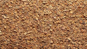 A textured surface of small, irregularly shaped brown flakes resembling bark or mulch. photo
