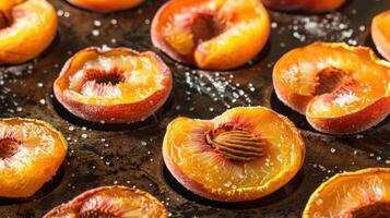 Sliced peaches arranged on a baking tray, likely prepared for roasting or baking. photo