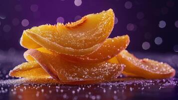 A close-up of sugar-coated peach slices stacked on a dark surface with a blurred background. photo