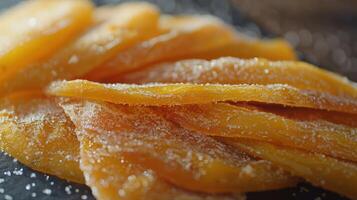 A close-up of sweet, dried mango slices dusted with sugar, showcasing a tasty snack. photo