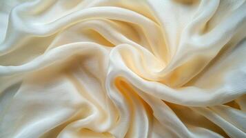 A close-up of soft, flowing cream-colored fabric, showcasing its texture and elegance. photo