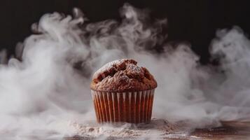 A chocolate muffin sits on a surface surrounded by wispy smoke, creating a dramatic effect. photo