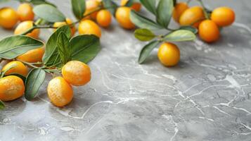 A cluster of bright yellow kumquats with green leaves on a textured surface. photo