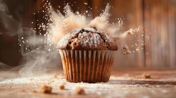 A freshly baked muffin with powdered sugar exploding in a cloud of flour. photo