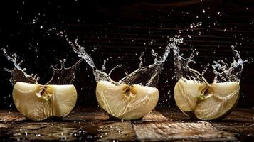 Slices of apple creating splashes in water against a dark background. photo