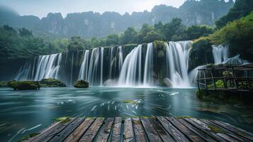 A serene waterfall cascading into a tranquil pool surrounded by lush greenery and mountains. photo
