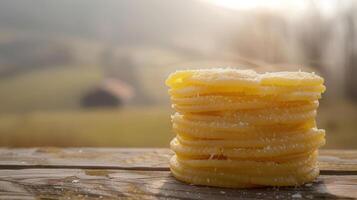 A stack of uncooked spaghetti on a wooden surface with a scenic background. photo