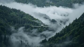 A small aircraft flying through a misty mountainous landscape surrounded by dense forests. photo