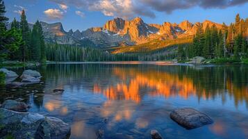 A serene lake reflecting mountains and trees during sunset. photo