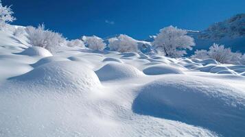 A serene winter landscape blanketed in smooth, untouched snow under a clear blue sky. photo