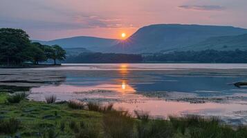 Serene sunset over a tranquil lake with mountains in the background. photo