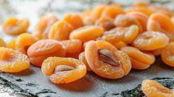 A close-up of dried apricots arranged on a rustic surface. photo