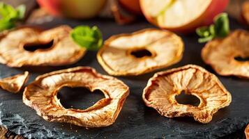 Dried apple slices arranged on a slate surface, showcasing a healthy snack option. photo