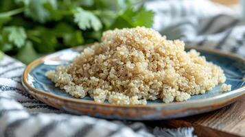 A plate of cooked quinoa served with fresh cilantro in the background. photo