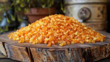 A mound of colorful granules resembling food ingredients on a wooden surface. photo